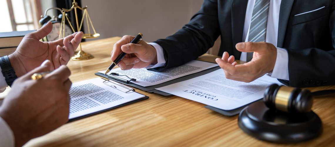 The lawyer working with a client discussing contract paper, a Business lawyer working about legal legislation in the courtroom to help their customer