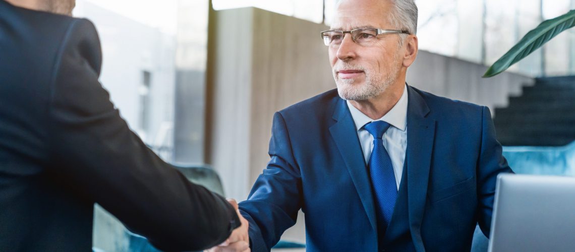 Handshaking between business partners after making a deal indoors